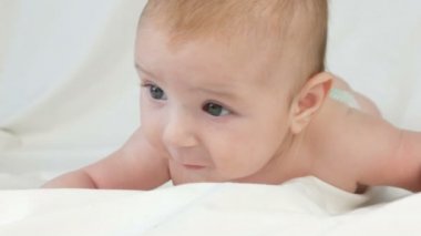 Midesi da annesinin yatak ve deneyimleri duyguları üzerinde yatan iki ay önce mutlu yeni doğmuş bebek. Bir bebek güler, görüşmeler, kollarını dalgalar. Çocuk yüz görünümü kapatın