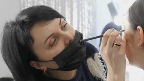 Επαγγελματίας στυλίστας make-up artist κάνει το smoky μακιγιάζ στα μάτια του ένα ασιατικό κορίτσι στο visage studio — Αρχείο Βίντεο
