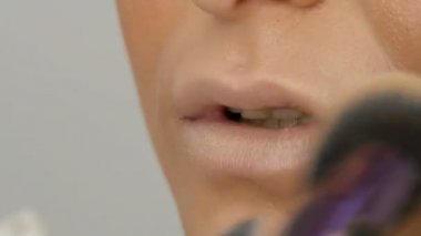 Profesyonel bir sanatçı makyaj için özel fırça ile güzel bir kız modeli, Tüylü toz, vurgulayıcı, temel krem makyaj yapar