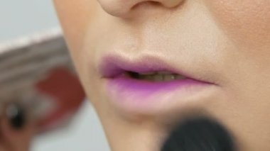 Profesyonel bir sanatçı makyaj için özel fırça ile güzel bir kız modeli, Tüylü toz, vurgulayıcı, temel krem makyaj yapar