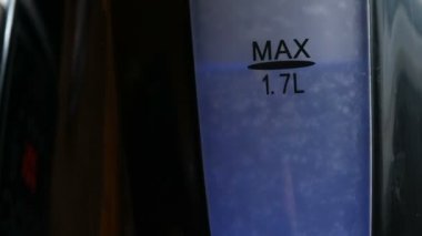 Siyah bir su ısıtıcısı şık mavi ekranda. Elektrikli çaydanlık suda kaynatın