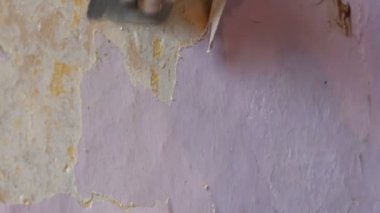 Erkek inşaatçılar el akıntılar ya da özel bir spatula ile duvar eski pembe duvar kağıdı kabuğu