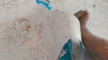 Adam temizler ve duvar kağıdı eski duvardan peeling