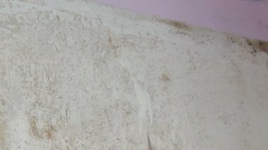 Adam temizler ve duvar kağıdı eski duvardan peeling