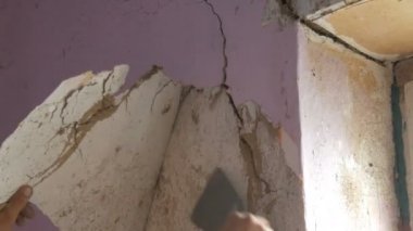 Bir duvar, ev onarım eli ayağı tutmaz pembe duvar kağıdı. Özel spatula ile eski duvar kağıdı soyulması adam.