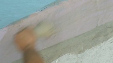 Adam eski odada tamirat yapıyor. Beyaz Vintage püskül ile duvarları boyar