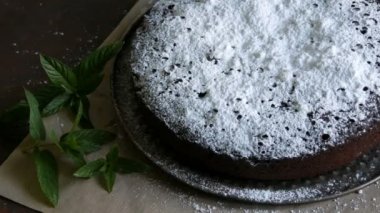 Şık ev yapımı fırında çikolatalı browni kek cömertçe bir pudra şekeri yanında taze nane yaprakları ile toz.