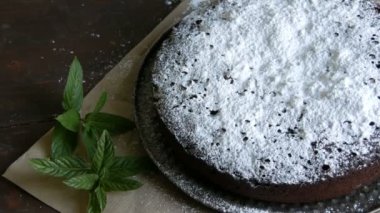 Şık ev yapımı fırında çikolatalı browni kek cömertçe bir pudra şekeri yanında taze nane yaprakları ile toz.