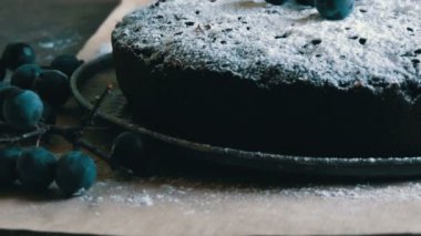 Çikolatalı kek kek cömertçe şık yanındaki mavi çilek yalan pudra şekeri ile kaplı.