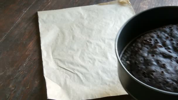 La mano femenina en guante de cocina azul pone pastel de chocolate casero recién horneado en la mesa — Vídeo de stock