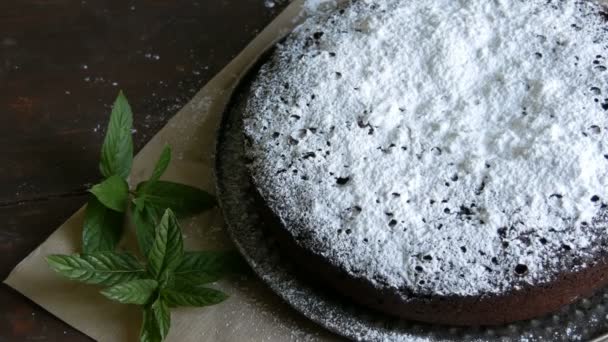 Stílusos házi sült csokoládé brownie torta nagylelkűen porcukorral egy hab mellett friss mentalevél — Stock videók