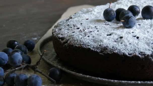 Chocoladetaart brownie royaal bedekt met poedersuiker stijlvol liggen naast de blauwe bessen — Stockvideo