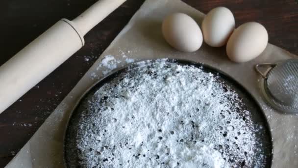 Bolo de chocolate cozido no forno caseiro Brownie Muffin em pó com açúcar contra um fundo de ovos e rolo de madeira Pin — Vídeo de Stock