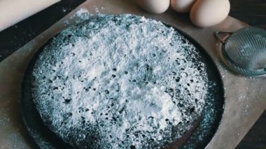 Toz şeker, yumurta ve ahşap oklava bir arka plan ile ev yapımı fırında çikolatalı browni kek