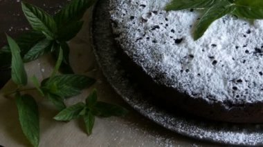 Şık ev yapımı fırında çikolatalı browni kek cömertçe bir pudra şekeri yanında taze nane yaprakları ile toz.