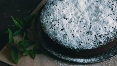 Şık ev yapımı fırında çikolatalı browni kek cömertçe bir pudra şekeri yanında taze nane yaprakları ile toz.