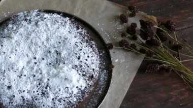 Ev yapımı taze pişmiş çikolatalı browni kek şeker yalan şık kuru çayır çiçek yanında krema ile toz