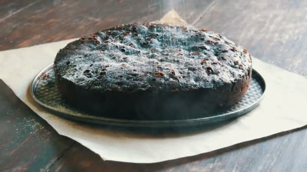 Pó de bolo de brownie de chocolate muito grande em cima com açúcar de confeiteiro branco — Vídeo de Stock