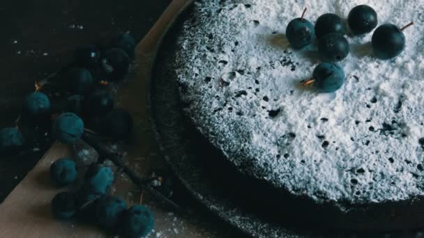 Schokoladenkuchen Brownie großzügig mit Puderzucker bedeckt stilvoll neben den blauen Beeren liegen — Stockvideo