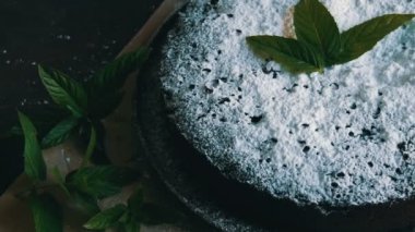Şık ev yapımı fırında çikolatalı browni kek cömertçe bir pudra şekeri yanında taze nane yaprakları ile toz.