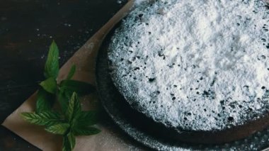 Şık ev yapımı fırında çikolatalı browni kek cömertçe bir pudra şekeri yanında taze nane yaprakları ile toz.