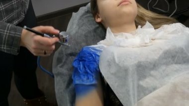 Moda Stüdyosu, model gösterisi için hazırlanıyor. Genç kız özel bir kanepede yatıyor, tasarımcı mavi boya ile özel bir Airbrush sprey kullanarak onu görüntü hazırlar