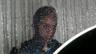 Yüksek moda. Bir model stüdyosunda poz siyah ve gümüş arka planda parlayan Rhinestones, parıltılı, metal kelebekler siyah bir maske bir uzaylı kız görüntü modeli.