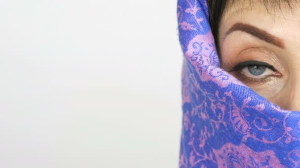 Retrato de una mujer árabe adulta de mediana edad con ojos azules grandes e inusuales con pestañas largas en paño islámico tradicional niqab o burka. Primer plano de la hermosa mujer musulmana — Vídeos de Stock