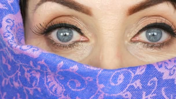 Portrait d'une femme adulte arabe d'âge moyen avec de beaux grands yeux bleus inhabituels avec de longs cils en tissu islamique traditionnel niqab ou burqa. Gros plan de belle femme musulmane — Video