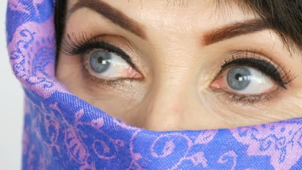 Portrait d'une femme adulte arabe d'âge moyen avec de beaux grands yeux bleus inhabituels avec de longs cils en tissu islamique traditionnel niqab ou burqa. Gros plan de belle femme musulmane — Video