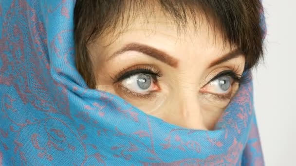 Портрет арабской взрослой женщины средних лет с необыкновенно красивыми большими голубыми глазами с длинными ресницами в традиционном ислам никабе или синей парандже. Закрыть красивую женщину — стоковое видео