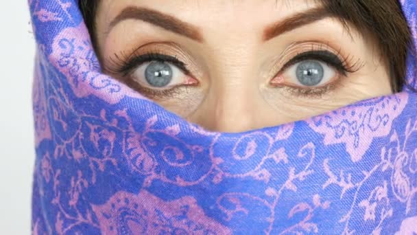 Retrato de una mujer árabe adulta de mediana edad con ojos azules grandes e inusuales con pestañas largas en paño islámico tradicional niqab o burka. Primer plano de la hermosa mujer musulmana — Vídeo de stock