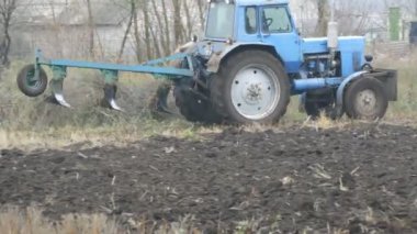 Mavi traktör, alanda geç sonbaharda çelik zemin küreler