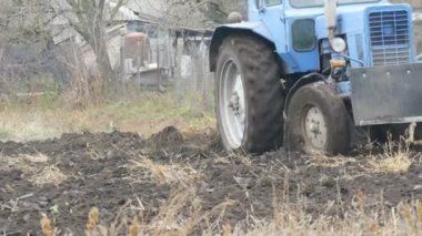 Mavi traktör, alanda geç sonbaharda çelik zemin küreler