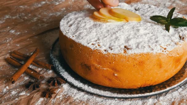 Čerstvě upečená svěží šťavnaté jablíčka, která je poseta práškovým cukrem, je ozdobena plátky nakrájeným řezem, vedle skořových tyčí a anýzy — Stock video