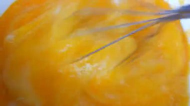 Mutfak el metal fırçalama yumurtadan yumurta sarısı, yumurta beyaz ve şeker bir kase yakın görünüm