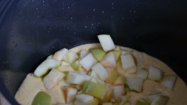 Apple Pie Charlotte pasta daha fazla pişirme kek elma dilimleri için bir Multicooker Pan içine dökün yukarıdan dökülür