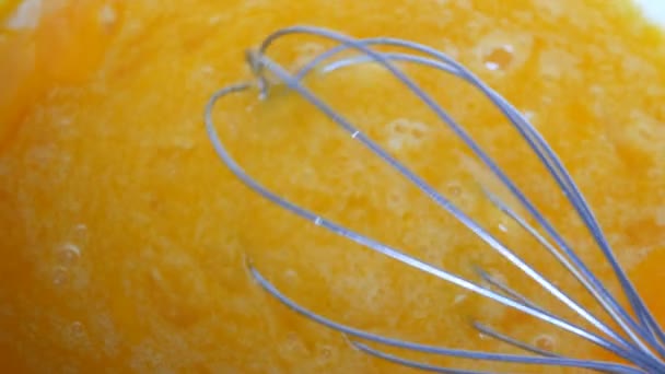 Кухня ручной металлический венчик взбивает яичный желток, яичный белок и сахар в миске закрыть вид — стоковое видео