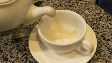 Çay beyaz porselen çaydanlık fincan içine dökülür