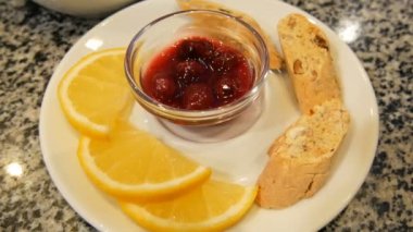 Kurabiye, limon dilimleri ve Berry Jam yanında, porselen beyaz Çaydanlık ve daire çay seti
