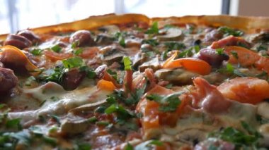 Buhar, yakın bir görünüm olan büyük bir taze pişmiş pizza. Domates, yeşillikler, Bavyera sosis, mantar, pastırma ile lezzetli pizza.