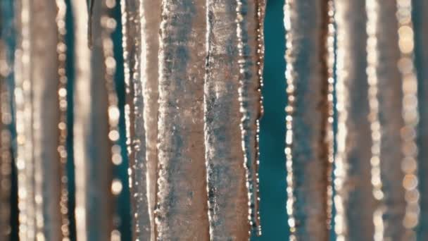 Ogromne grube sople wiszące z dachów topnieją pod wiosennym słońcem — Wideo stockowe