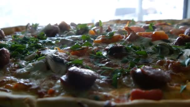 Duża świeżo upieczona Pizza, z której nie ma pary, z bliska. Pyszna pizza z pomidorami, zielonymi, bawarskimi kiełbaskami, grzybami, boczkiem. — Wideo stockowe