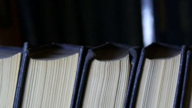 Kütüphanede bir kitaplıkta büyük eski kitapların satırı