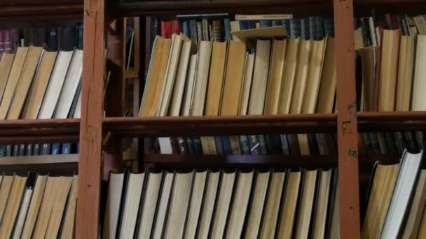 Muchos libros antiguos en los estantes de la biblioteca — Vídeo de stock