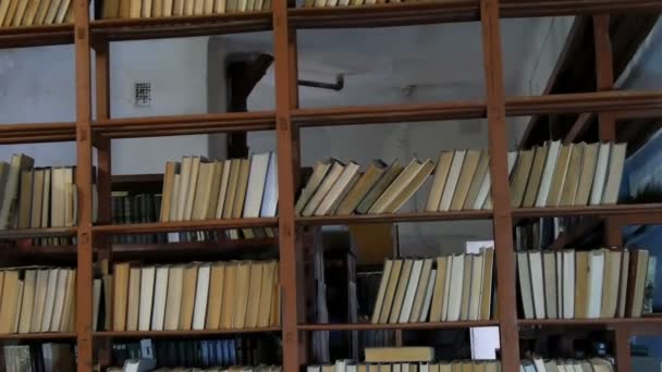 Много старых книг на полках в библиотеке — стоковое видео