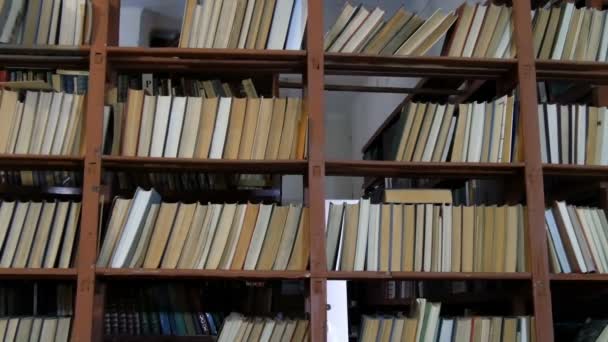 Muchos libros antiguos en los estantes de la biblioteca — Vídeo de stock