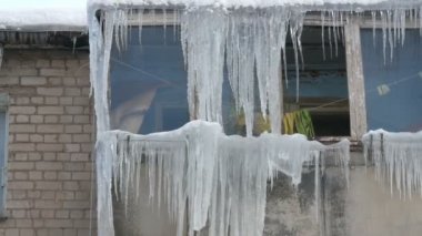 Eski terk edilmiş ev ve kış aylarında büyük miktarda erime buz sarkıtları ile balkon.