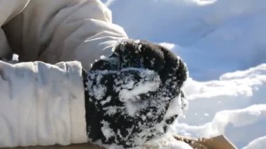 Genç çocuk kar ile oynar, snowballs yapar ve kışın elinde kar atar. Güzel güneşli kış günü