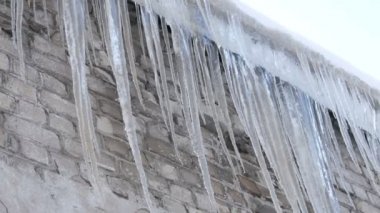 Kışın evin çatısında büyük erime buz sarkıtları çok sayıda